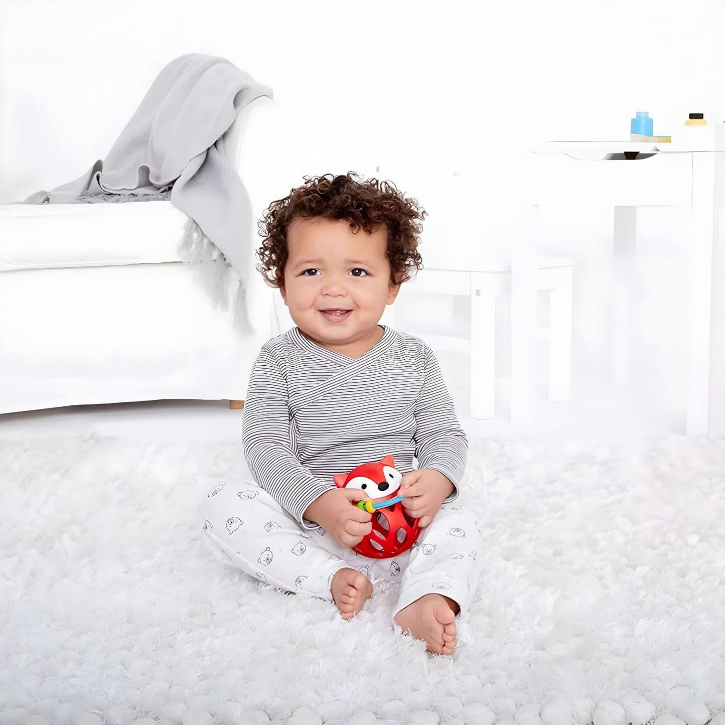 Bola Chocalho Raposa vermelha da Skip Hop nas mãos de bebés em momento de descoberta