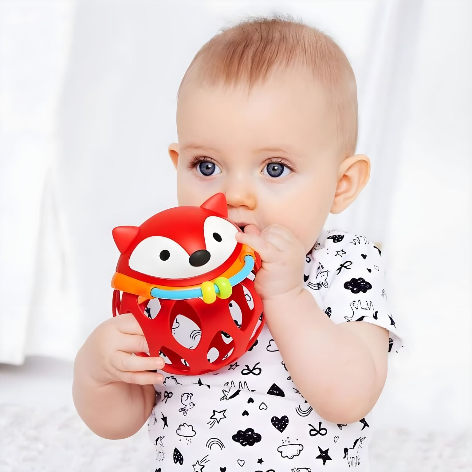 Bola Chocalho Raposa vermelha da Skip Hop nas mãos de bebés em momento de descoberta