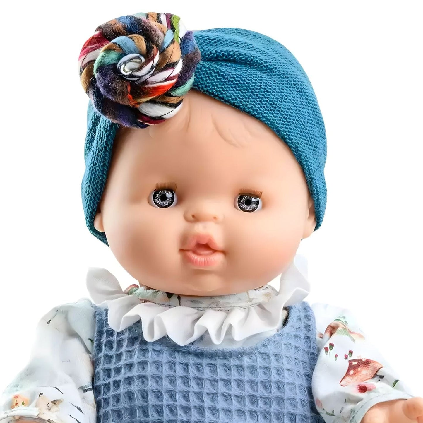 Boneca Blanca de Paola Reina com roupa azul, gola branca e turbante azul com flor colorida