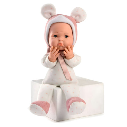 Boneca Mimi Rosa sentada num cubo branco com as mãos na boca