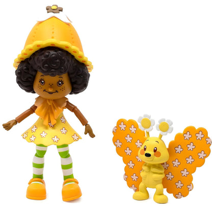 Boneca Strawberry Shortcake Orange Blossom de vestido amarelo ao lado da borboleta Marmalade