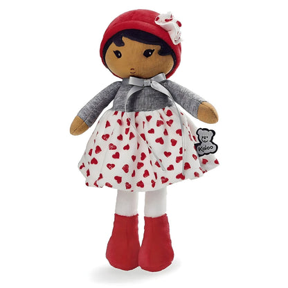 Boneca de Pano Jade da Kaloo com vestido branco de corações vermelhos, camisola cinzenta e gorro vermelho