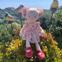 Boneca de pano Vendela com vestido floral rosa, laços cor-de-rosa e sapatos vermelhos