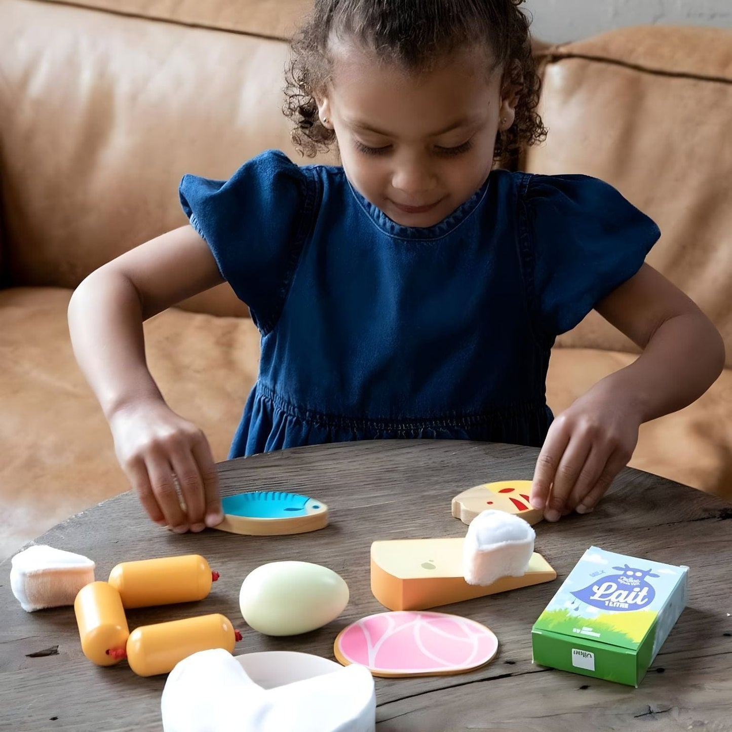 criança a brincar com conjunto de alimentos em madeira da Vilac com alimentos de faz de conta e caixa de leite