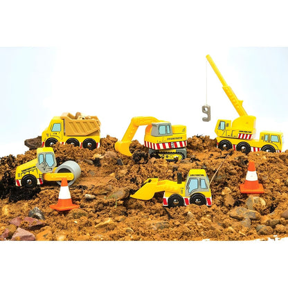 Criança a brincar com veículos de construção em madeira Le Toy Van, incluindo camião, grua, escavadora, pá e cones.