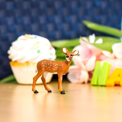 Figura Cria de Cervo da Virgínia sobre uma mesa com flores e bolo