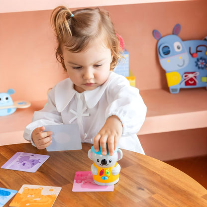 Criança a brincar com o Jogo Eu Aprendo: Aprendo com Coco da Diset com cartas ilustradas e boneco interativo