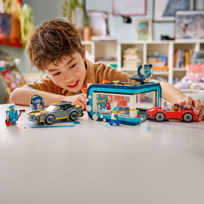 Rapaz brinca com o LEGO City Lavagem de Automóveis Drive-through sobre uma mesa