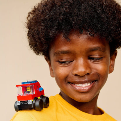 Criança sorridente com o Lego City Camião dos Bombeiros