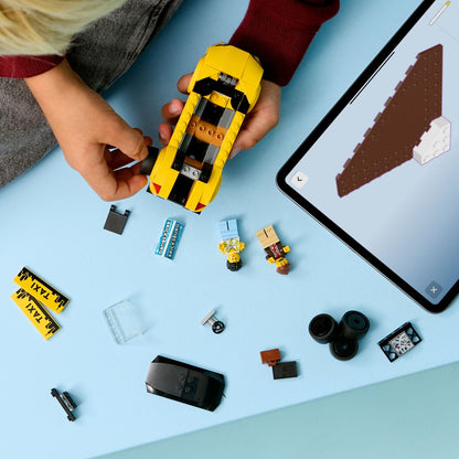 Criança a montar o Táxi Amarelo Lego City com tablet