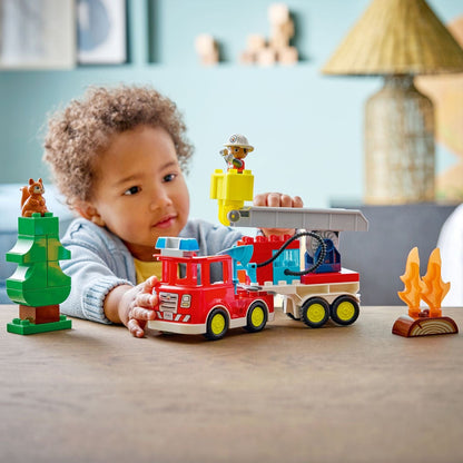 Criança a brincar com o Lego Duplo Camião dos Bombeiros sobre uma mesa