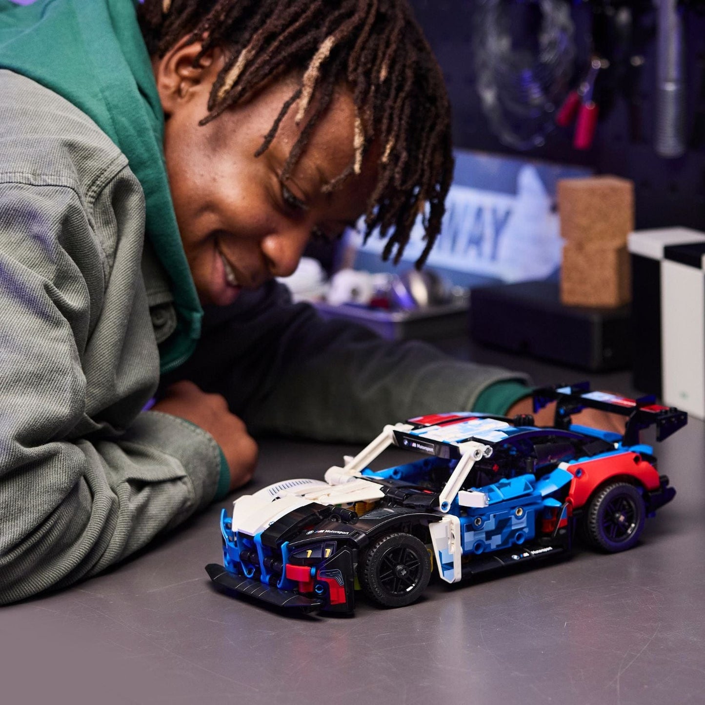 Lego Technic Carro de Corrida BMW M4 GT3 EVO modelo de corrida azul branco e vermelho em ambiente de brincadeira