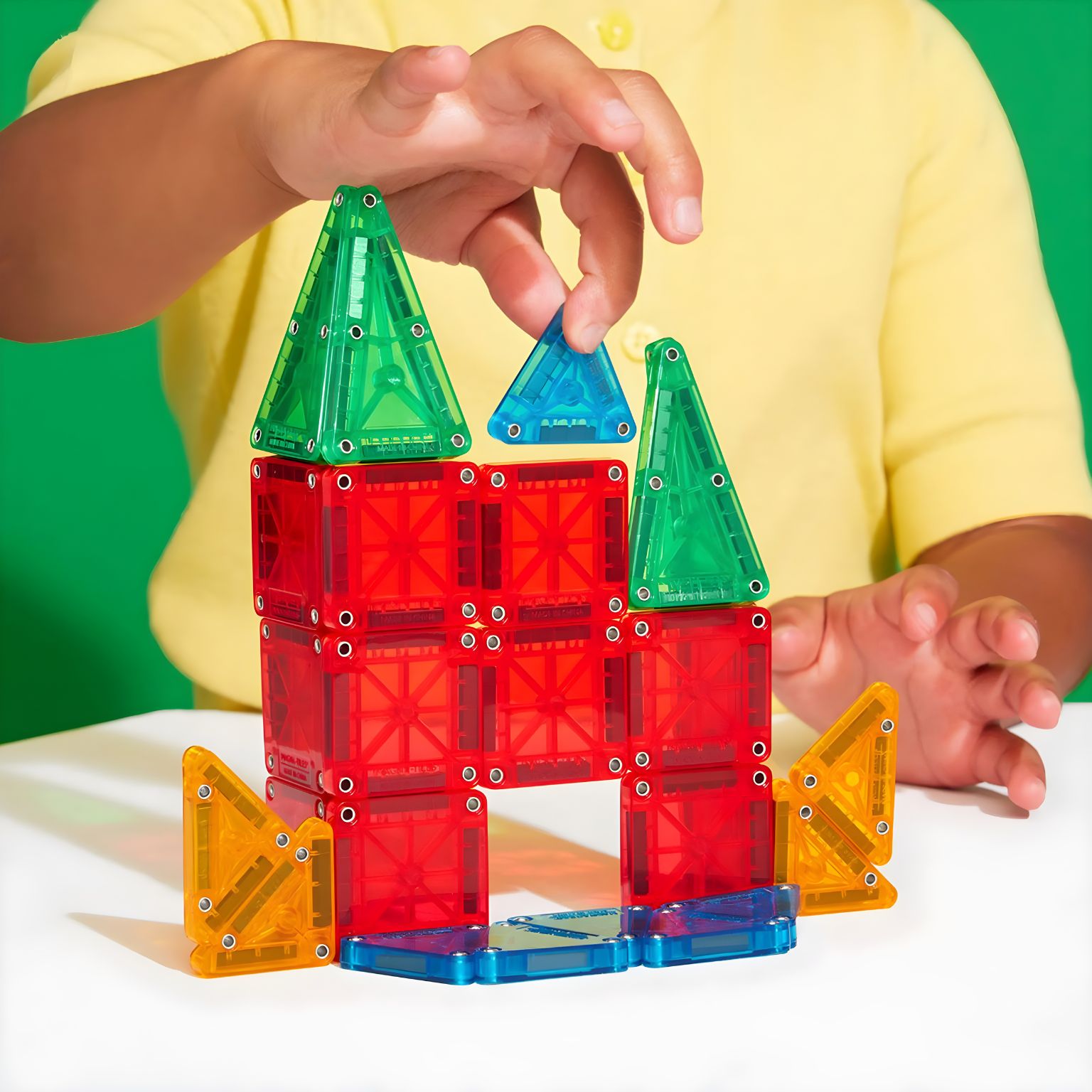 criança a brincar com Magna-Tiles Micromags Travel conjunto magnético de viagem colorido