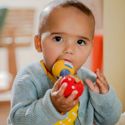 Bebé a brincar com Maracas do cão Dachshund coloridas da Spiegelburg