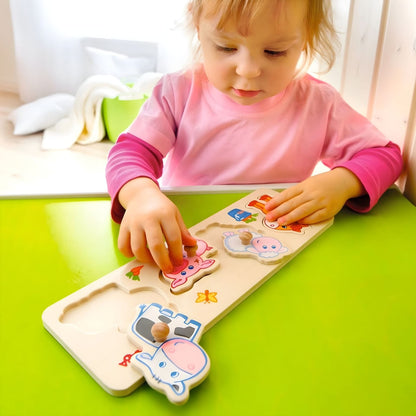 Menina a encaixar as peças do Puzzle Animais bebé da Quinta