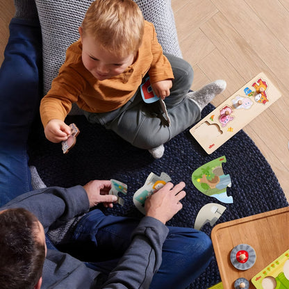 Bebé e adulto a brincar com o Puzzle de Encaixe no chão