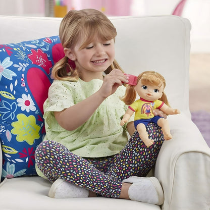 Menina a pentear a Baby Alive Littles Astrid no sofá