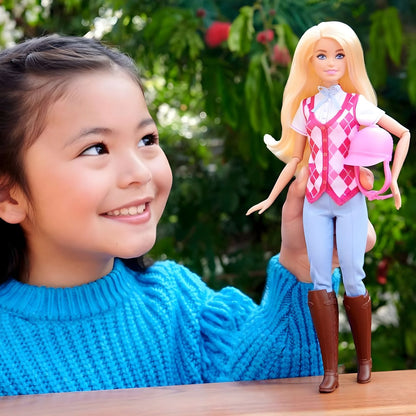 Menina sorridente a segurar a Barbie Mysteries The Great Horse Chase