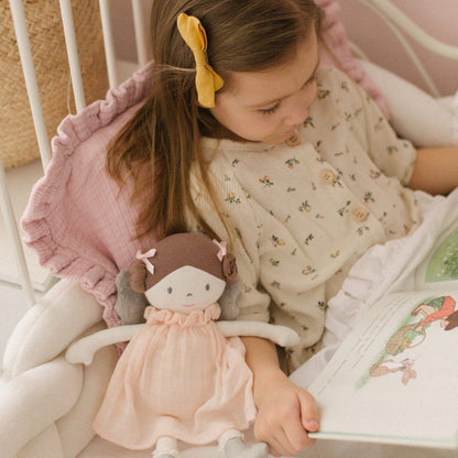 Menina a ler um livro com a Boneca de Pano Fada Angelina ao lado