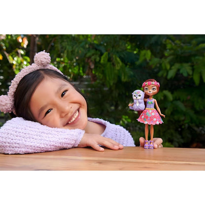 Menina sorridente com a boneca Enchantimals Oneda Otter