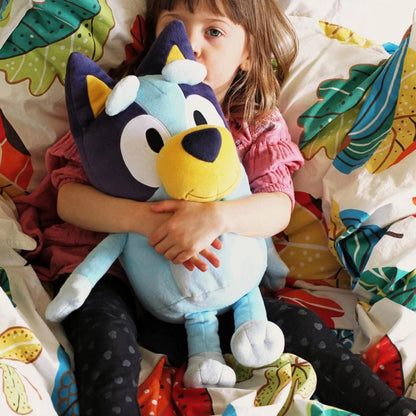 Menina deitada a abraçar o peluche da Bluey