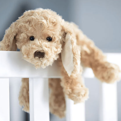 Cão de peluche 25 cm encostado à grade de um berço
