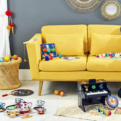 Conjunto de Chá musical Rainbow no chão de uma sala com sofá amarelo