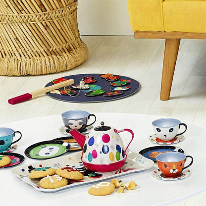 Conjunto de Chá musical Rainbow sobre um tabuleiro com bolachas, numa sala