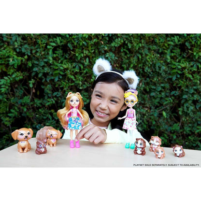 Menina a brincar com bonecas Enchantimals e porquinhos-da-índia numa mesa