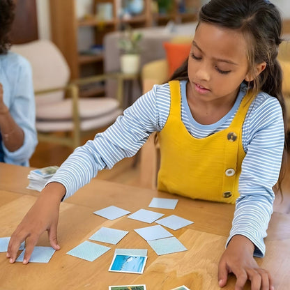 Menina a virar cartas do Jogo de memória Stitch Challenge numa mesa