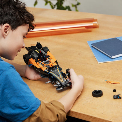 Rapaz a montar o carro LEGO Technic NEOM McLaren numa mesa