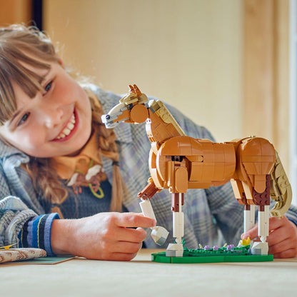 Menina sorridente a montar o LEGO Creator Cavalo Encantador