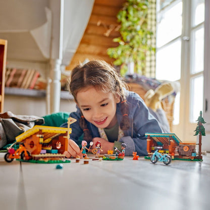 Menina deitada a brincar com as Cabanas LEGO Friends do Campo Aventura