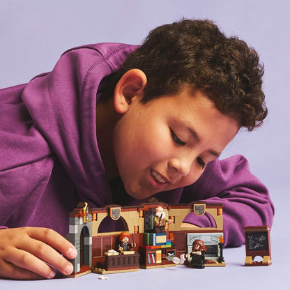 Rapaz a brincar com o LEGO Harry Potter Aula de Encantamentos