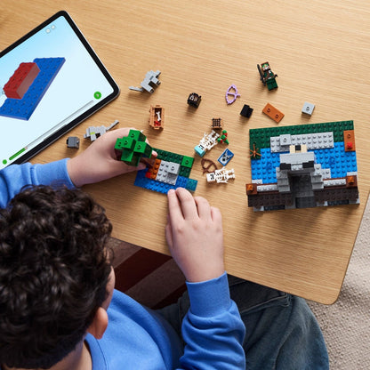 Criança a montar A Fortaleza dos Lobos LEGO Minecraft com um tablet ao lado