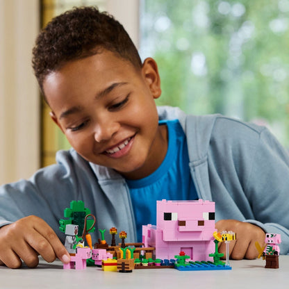 Rapaz sorridente a brincar com o LEGO Minecraft A Casa do Porco Bebé