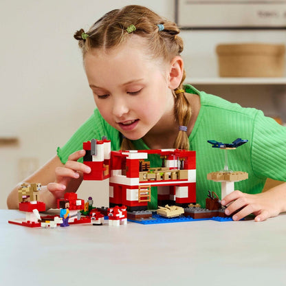 Menina a montar o LEGO Minecraft A Casa Mooshroom numa mesa