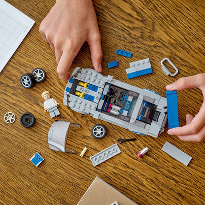 Mãos a montar o Nissan Skyline LEGO Speed Champions com peças soltas na mesa