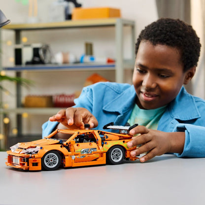 Rapaz a brincar com o LEGO Technic Toyota Supra MK4 montado