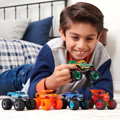 Rapaz deitado a brincar com vários camiões Monster Jam