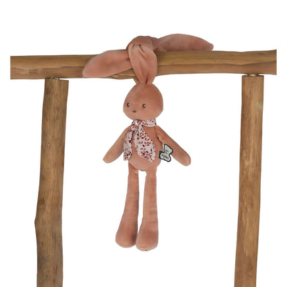 Peluche Coelho Terracota pendurado pelas orelhas numa trave de madeira