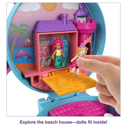 Mão a colocar uma boneca na casa de praia do Polly Pocket Golfinho