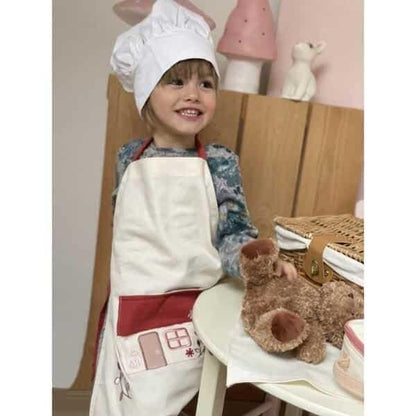 Criança com chapéu de cozinheiro a usar o Avental A casa