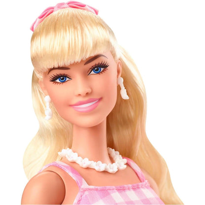 Rosto da Barbie The Movie com fita rosa no cabelo e colar de pérolas
