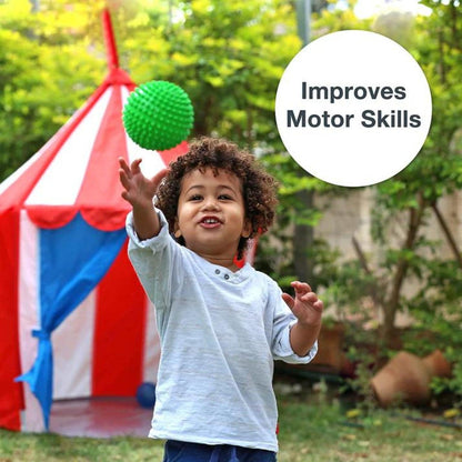 Criança ao ar livre a apanhar a Bola Sensorial Verde no ar