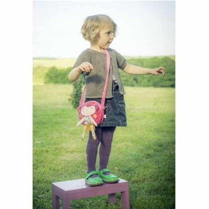 Menina de pé com a Bolsa Betty ao ombro num campo