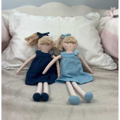 Boneca com Vestido Azul ao lado de outra boneca num sofá