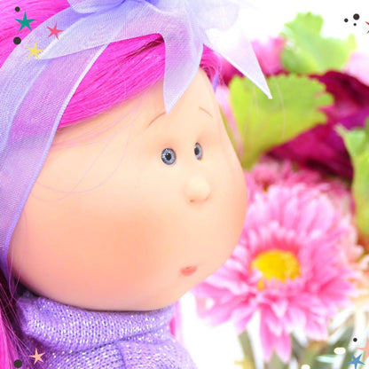 Rosto da boneca Mia de cabelo rosa junto a flores