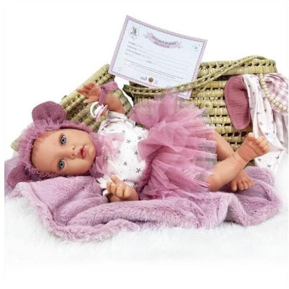 Boneca Susette Reborn deitada numa alcofa de verga com manta lilás