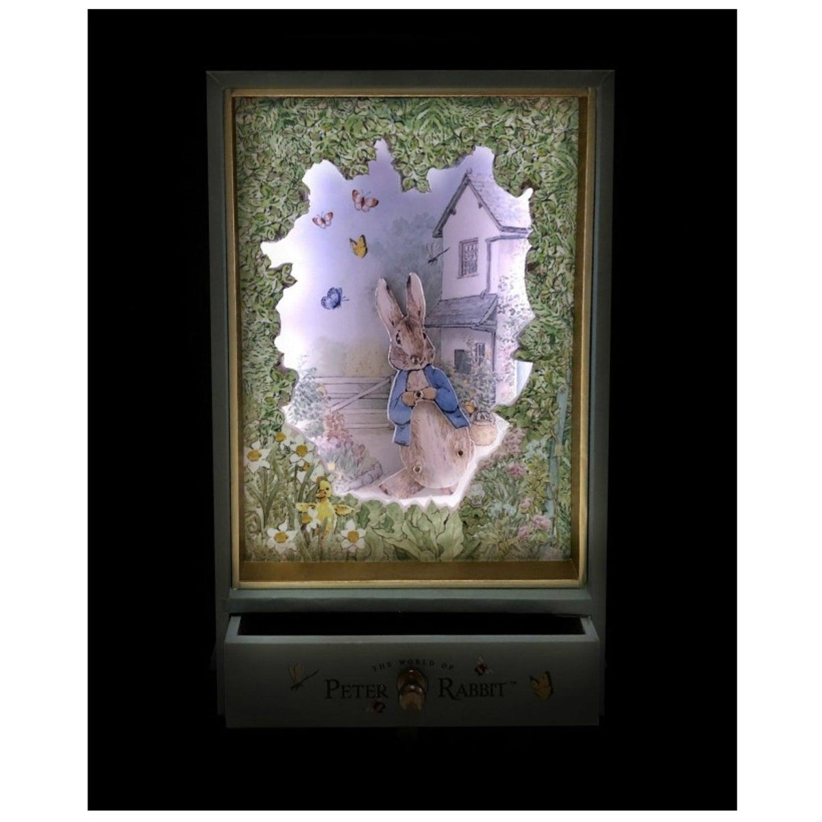 Caixa musical Peter Rabbit Garden com o cenário iluminado e a gaveta aberta